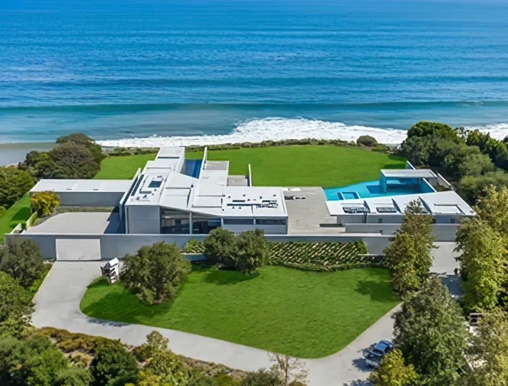 The spacious backyard has a swimming pool and ends with a cliff overlooking the beach.