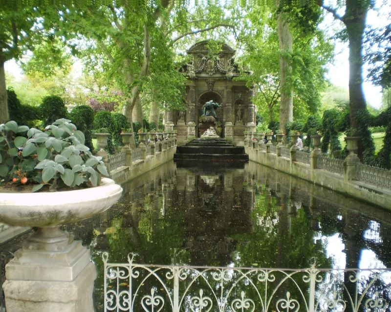 A view of Luxembourg Gardens with its manicured lawns, tree-lined pathways, and central fountain