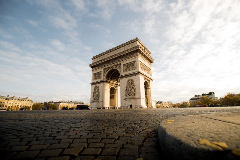 Arc de Triomphe: A monumental arch against a blue sky, Paris