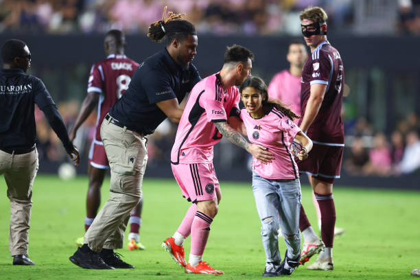 Lionel Messi of Inter Miami interacts with a fan that rushed the field during the second half of a game against the Colorado Rapids at DRV PNK...