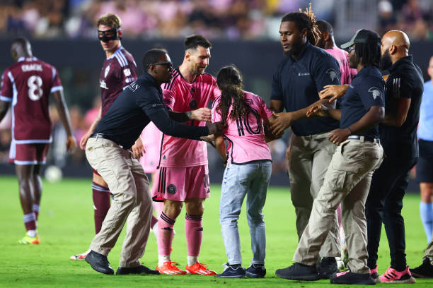 Lionel Messi of Inter Miami interacts with a fan that rushed the field during the second half of a game against the Colorado Rapids at DRV PNK...