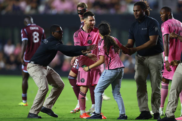 Lionel Messi of Inter Miami interacts with a fan that rushed the field during the second half of a game against the Colorado Rapids at DRV PNK...