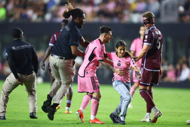 Lionel Messi of Inter Miami interacts with a fan that rushed the field during the second half of a game against the Colorado Rapids at DRV PNK...