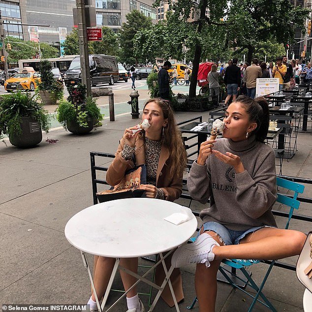 Cute pal: The ex of Justin Bieber was sitting next to a female friend who had a cute outfit consisting of a camel coat over a leopard-print shirt. Thursday is National Best Friend's Day