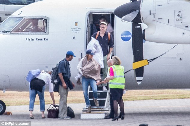 Touch down! The family was also seen disembarking a plane earlier that day