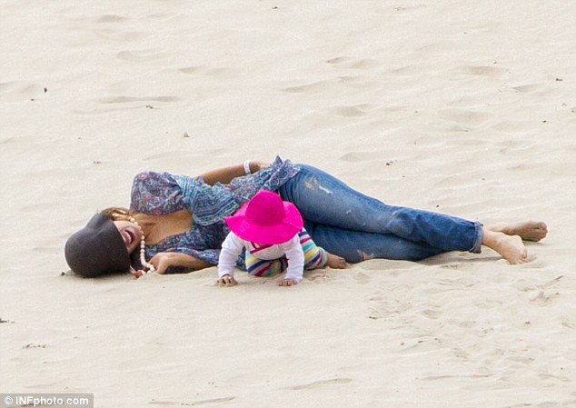 Getting playful: The mother and daughter lounged in the sand together