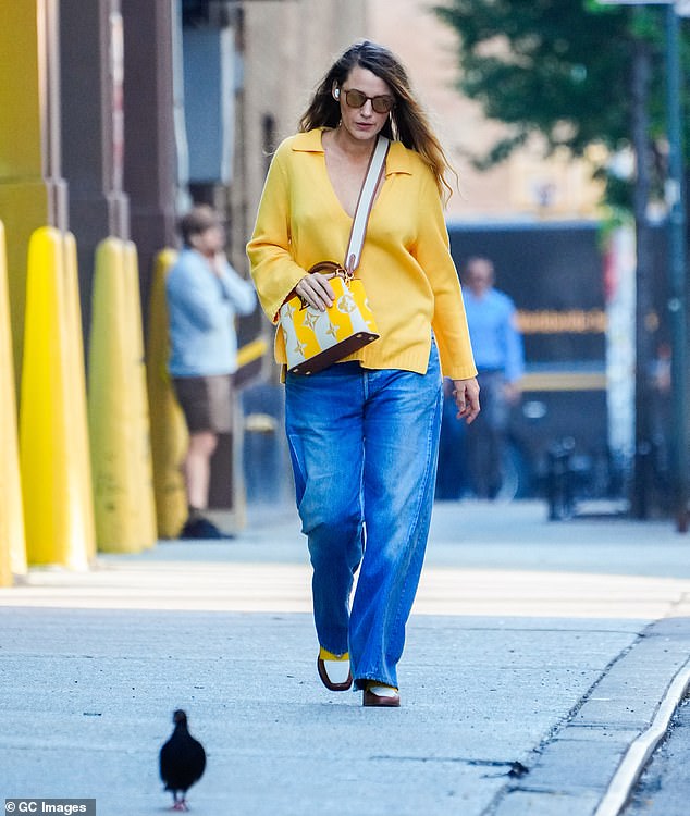 Stroll:The actress, 36, caught the eye in a plunging canary yellow top, teamed with flared jeans and matching Nomasei loafers